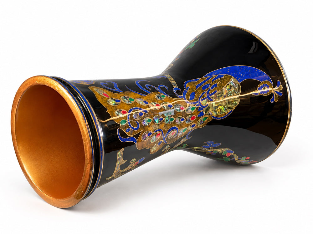 Sala Midnight Peacock Sombaty darbuka on its side, showing the open base and a blue-and-gold peacock with colorful tail details on a dark finish.